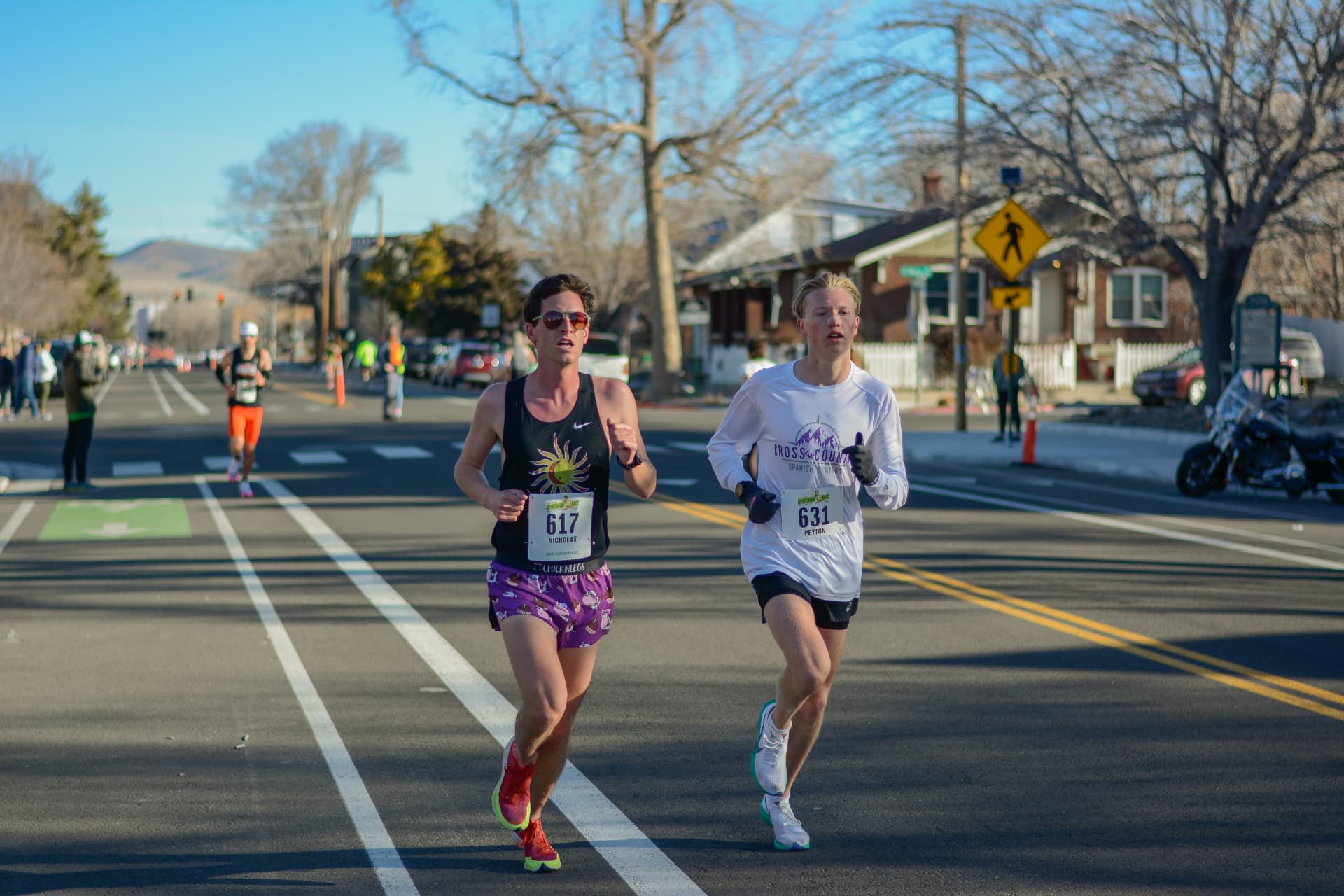 Two front runners pushing the pace through a quiet neighborhood