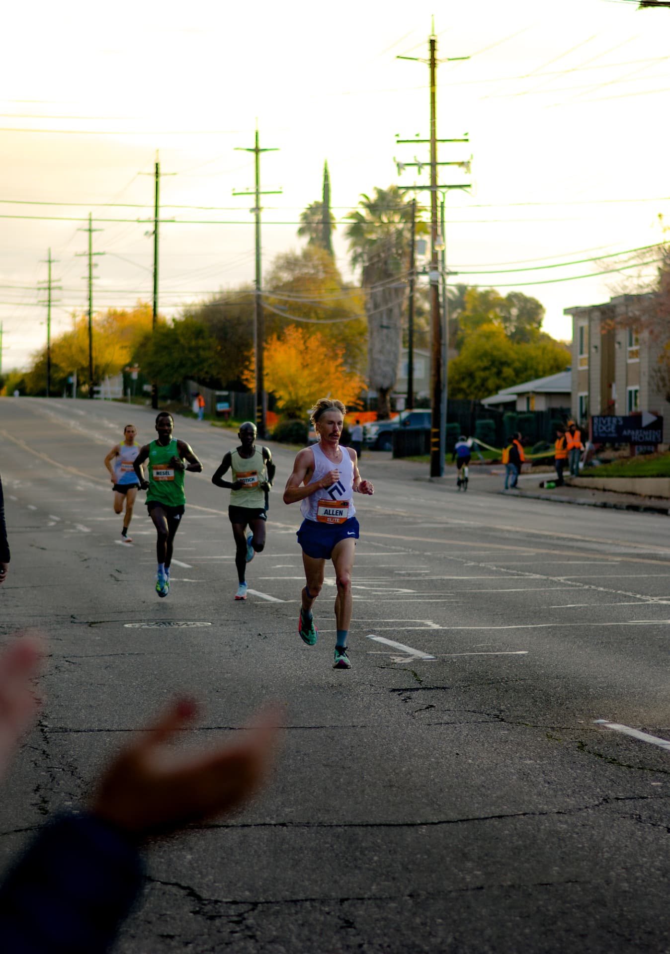 An elite runner pulling away from the chase pack at sunrise